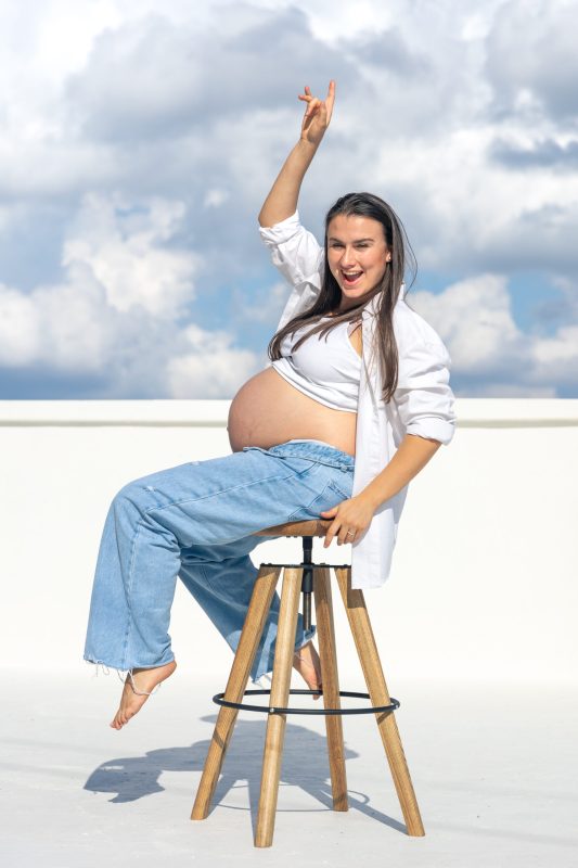 Joyful pregnant woman on the background of the sky. Concept of pregnancy. . High quality photo