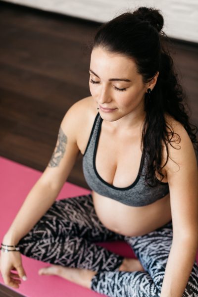 Pregnant young woman doing breathing and relaxation exercises